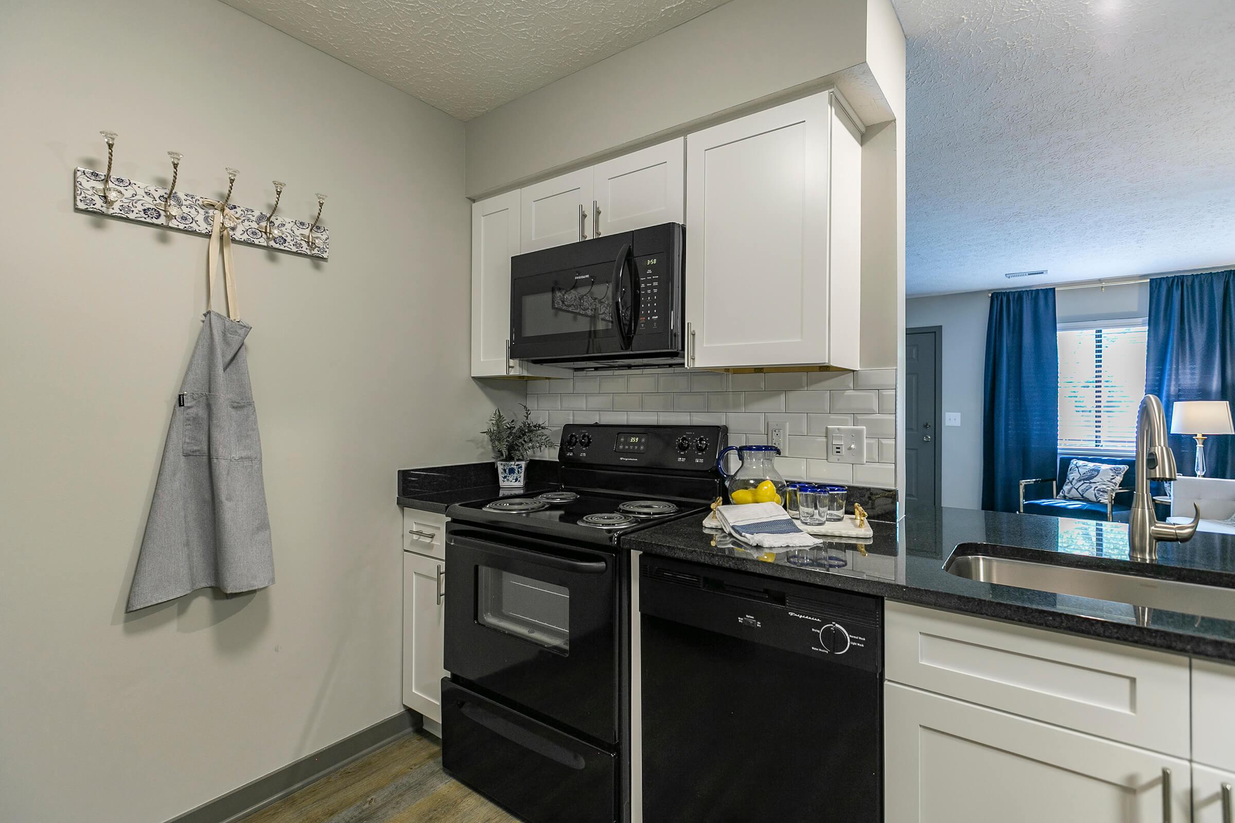 Kitchen with a black stove and silver appliances.